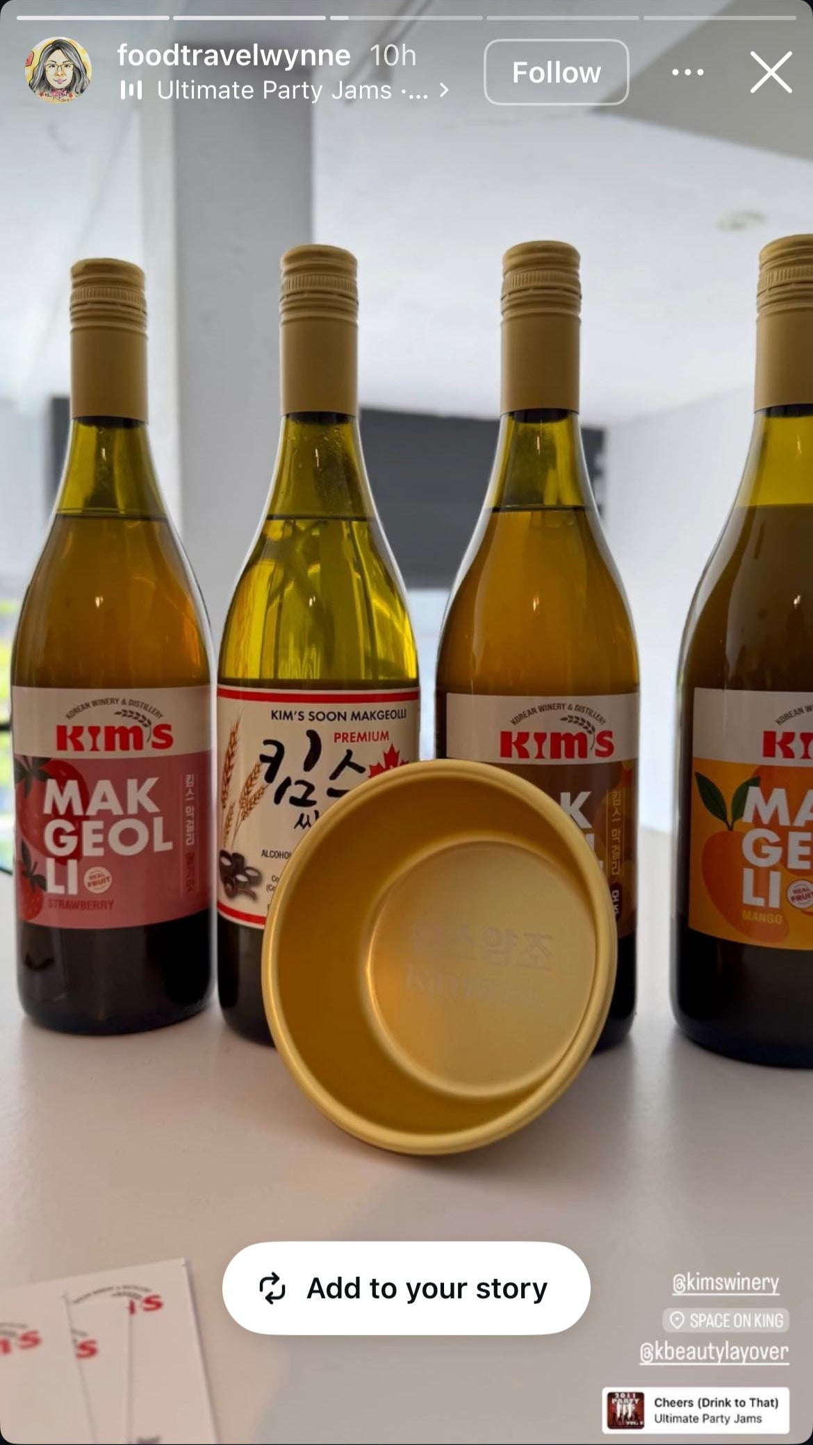 Four bottles of Kim's Makgeolli including strawberry, original, moju (ginger cinnamon) and mango, with a golden aluminum makgeolli bowling on a table.