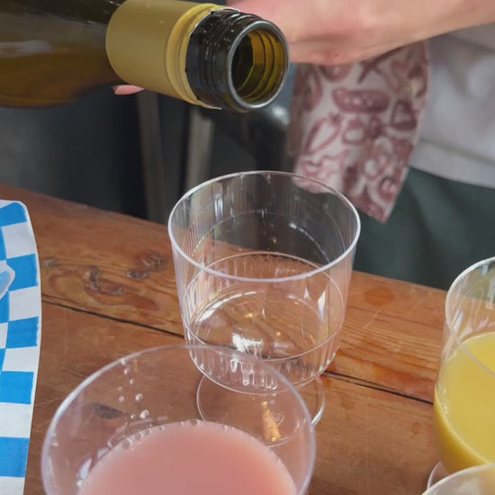 Kim’s Makgeolli Moju being poured into a wine glass, showing smooth golden brown rice wine.